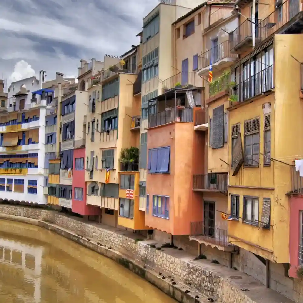 Aerial view of Gerona, Spain, with historic architecture and colorful riverside houses.