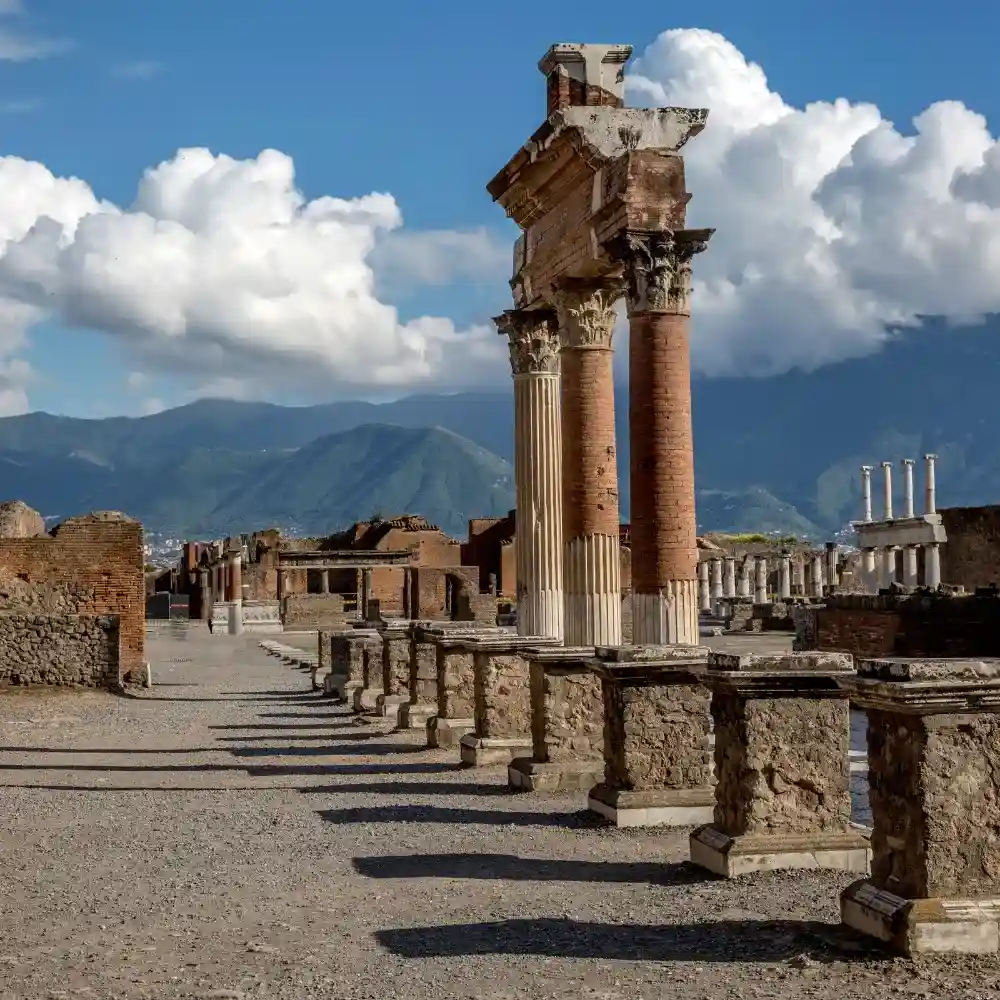 Ancient ruins of Pompeii with Mount Vesuvius in the background.